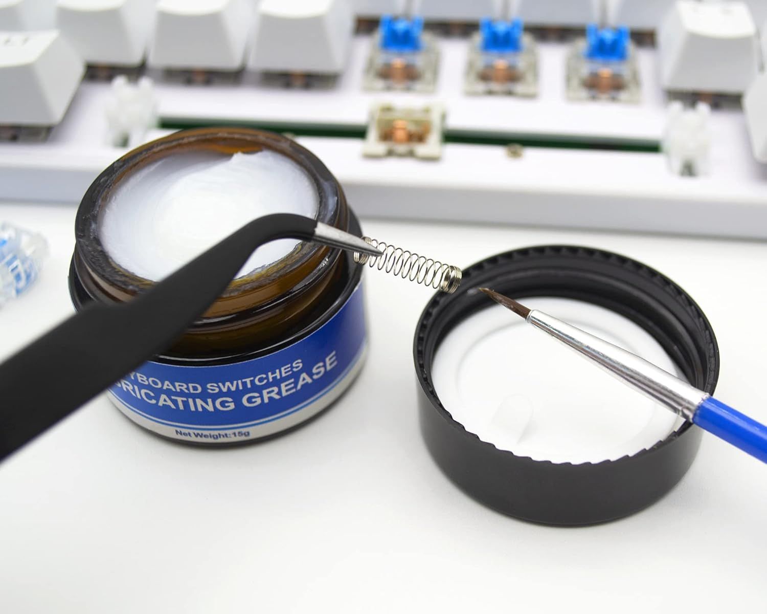 Demonstrates the product's use for keyboard switches, showing the grease container and application tool to communicate ease of maintenance and lubrication.