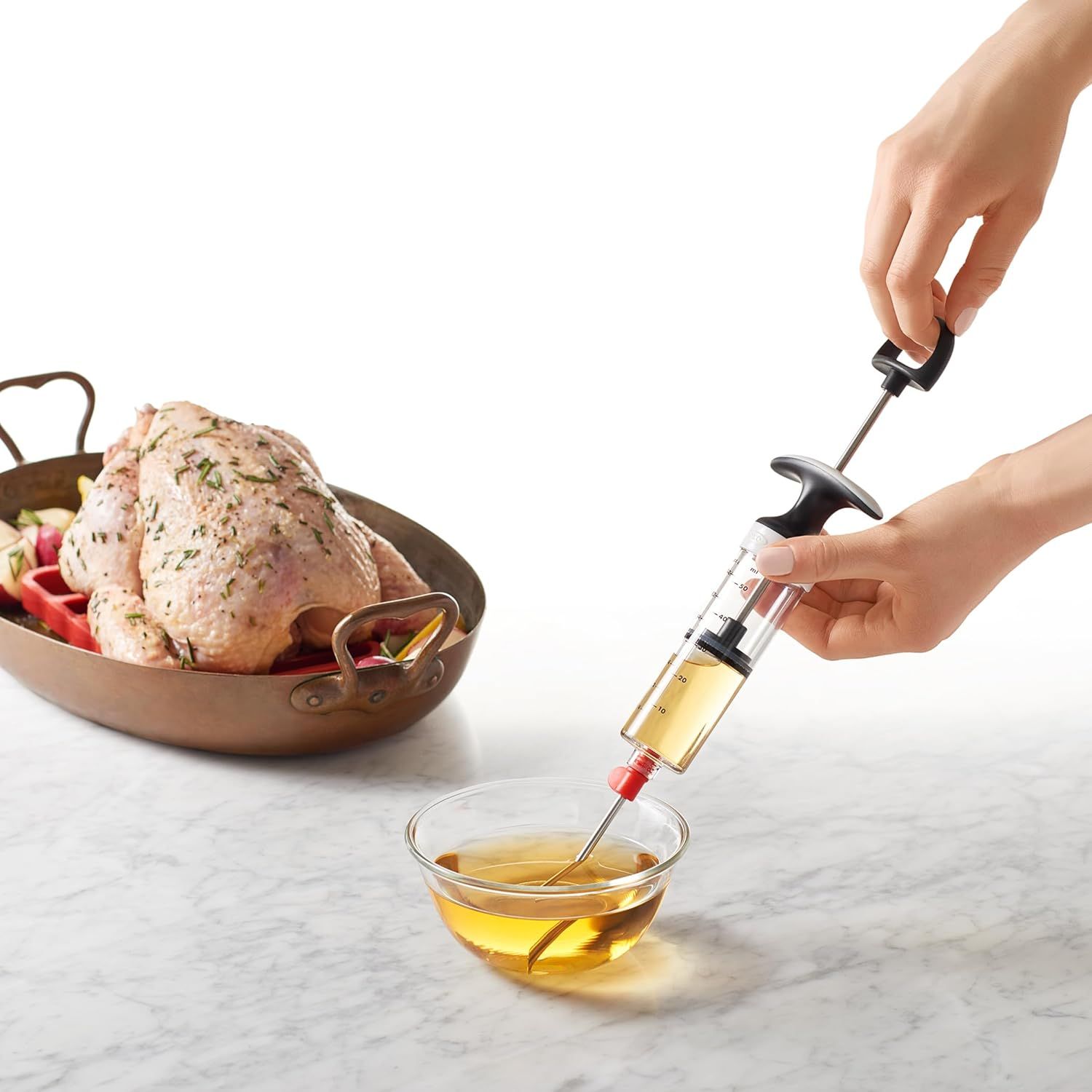 Demonstrates how to use the marinade injector to baste or inject liquid into meat, showing the product in action to help shoppers understand its usage.