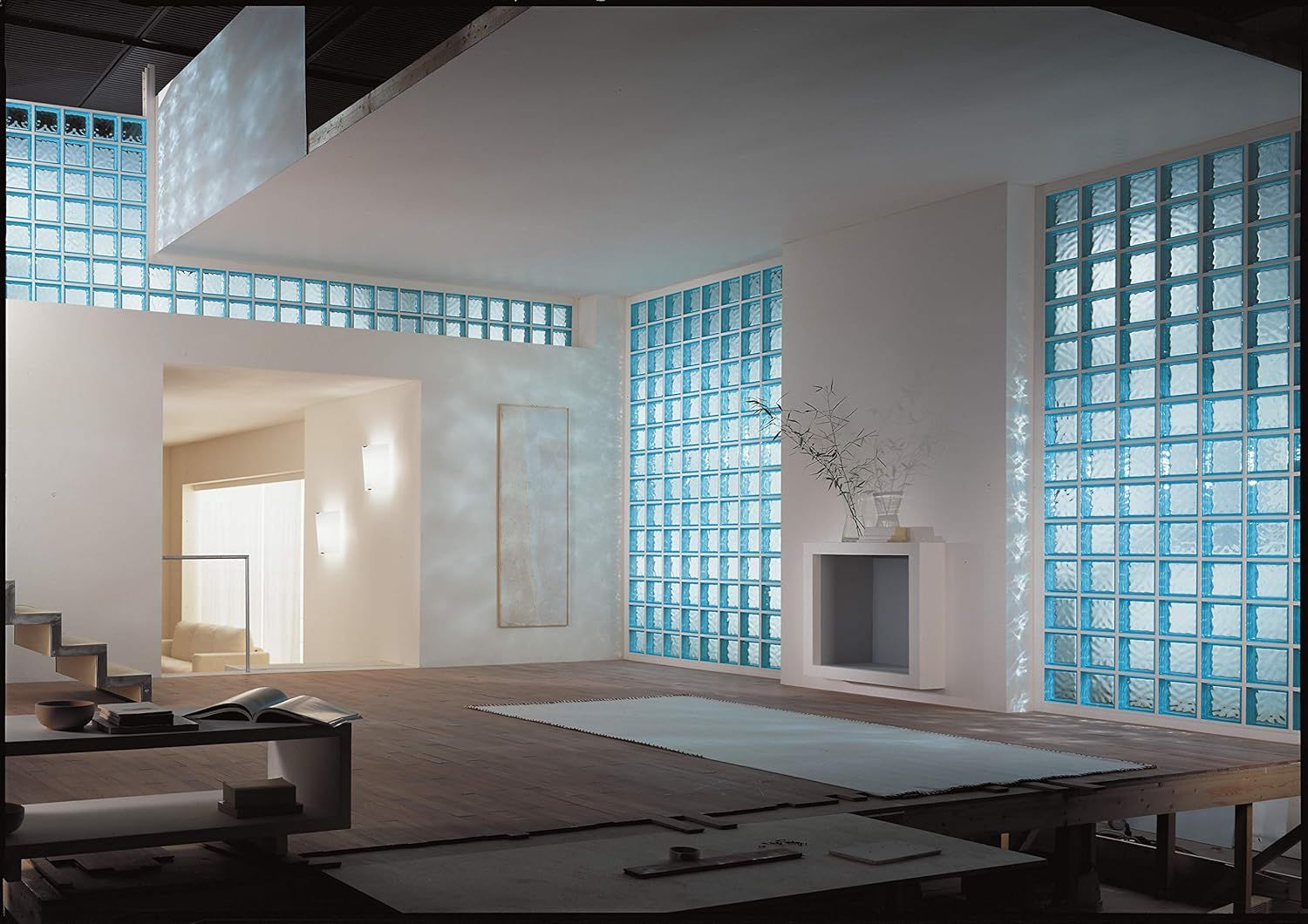 Showcases the product (glass block walls) in a real-world modern interior setting to help shoppers visualize how it looks in an actual space, emphasizing aesthetic appeal and natural light diffusion.