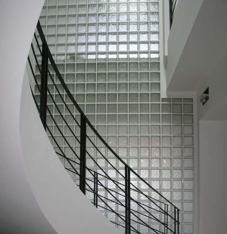Showcases the product (glass blocks) installed in a real-world architectural setting to demonstrate its aesthetic appeal and practical application in modern interior spaces.