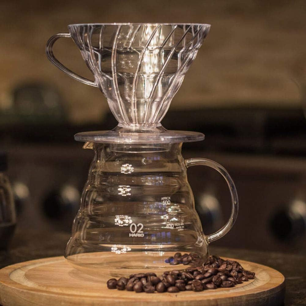 Displays the complete coffee brewing system (dripper and carafe) in a clean, lifestyle-styled setting to show the product's design and how it looks when assembled.