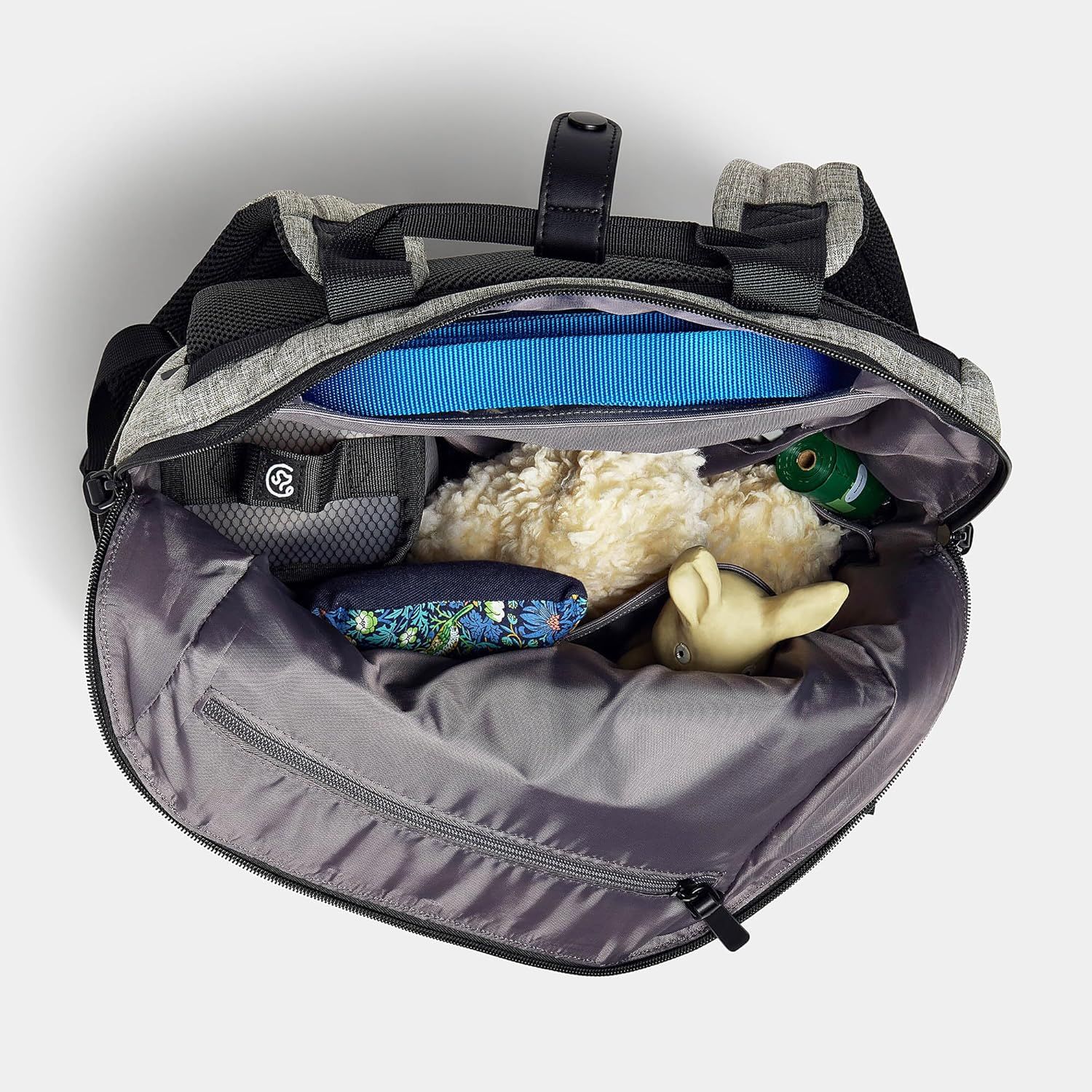 Shows what fits inside the backpack and demonstrates its capacity by displaying pet toys, water bottle, and other accessories packed inside.