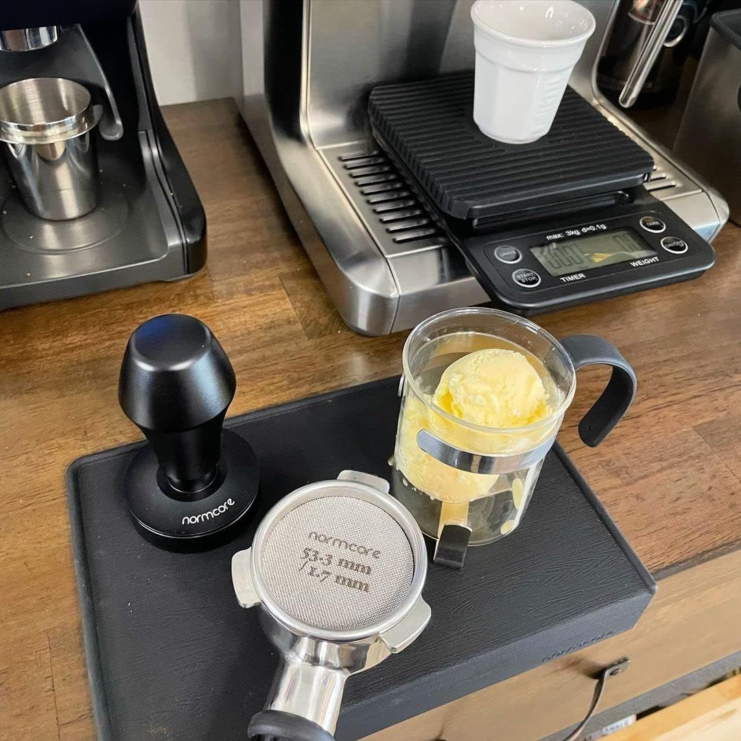 Displays the product in a real coffee-making environment to show how it fits into a home barista setup.