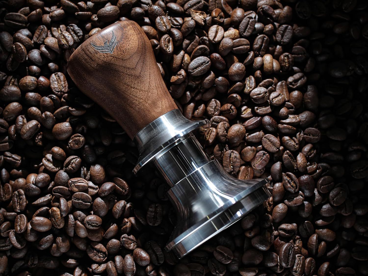 Showcases the coffee tamper in a real-world coffee preparation setting with coffee beans to create an authentic, aspirational lifestyle appeal.