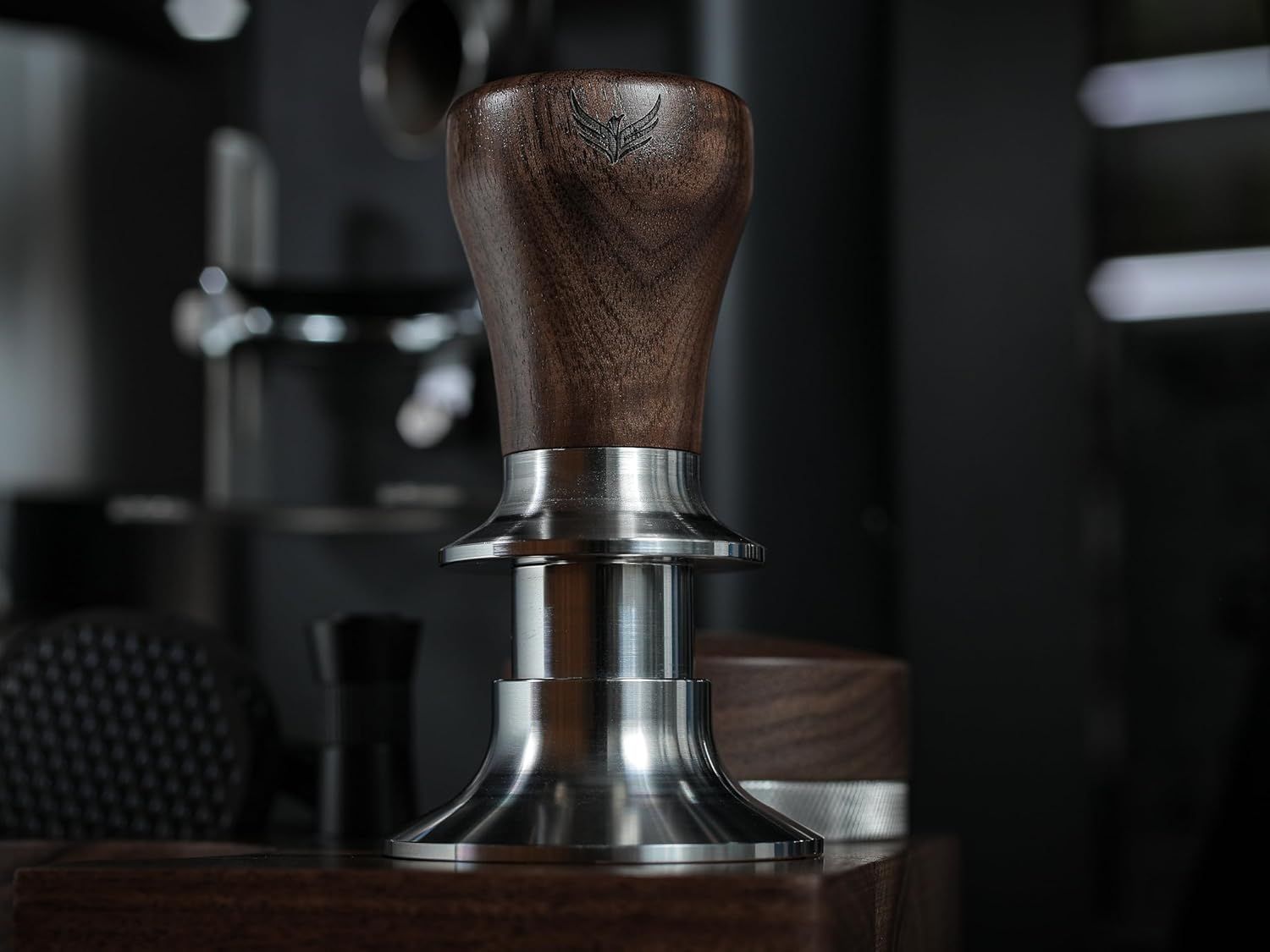 Presents the tamper in a professional coffee environment to convey quality and craftsmanship without text distractions.