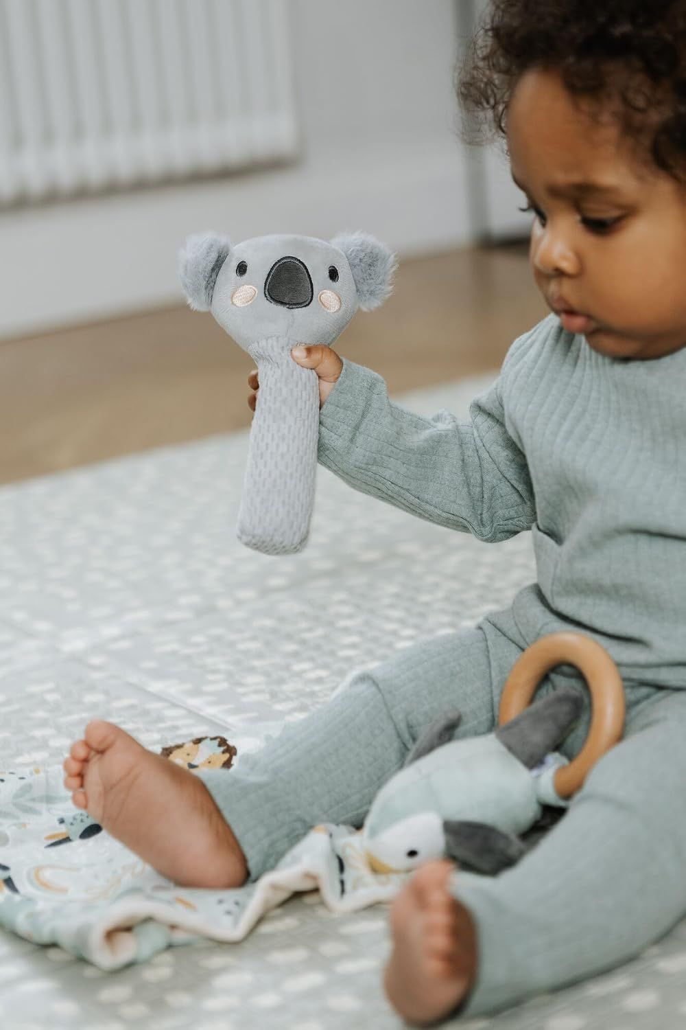 Shows the product in real-world use with a baby to help shoppers visualize how their child would interact with the toy.