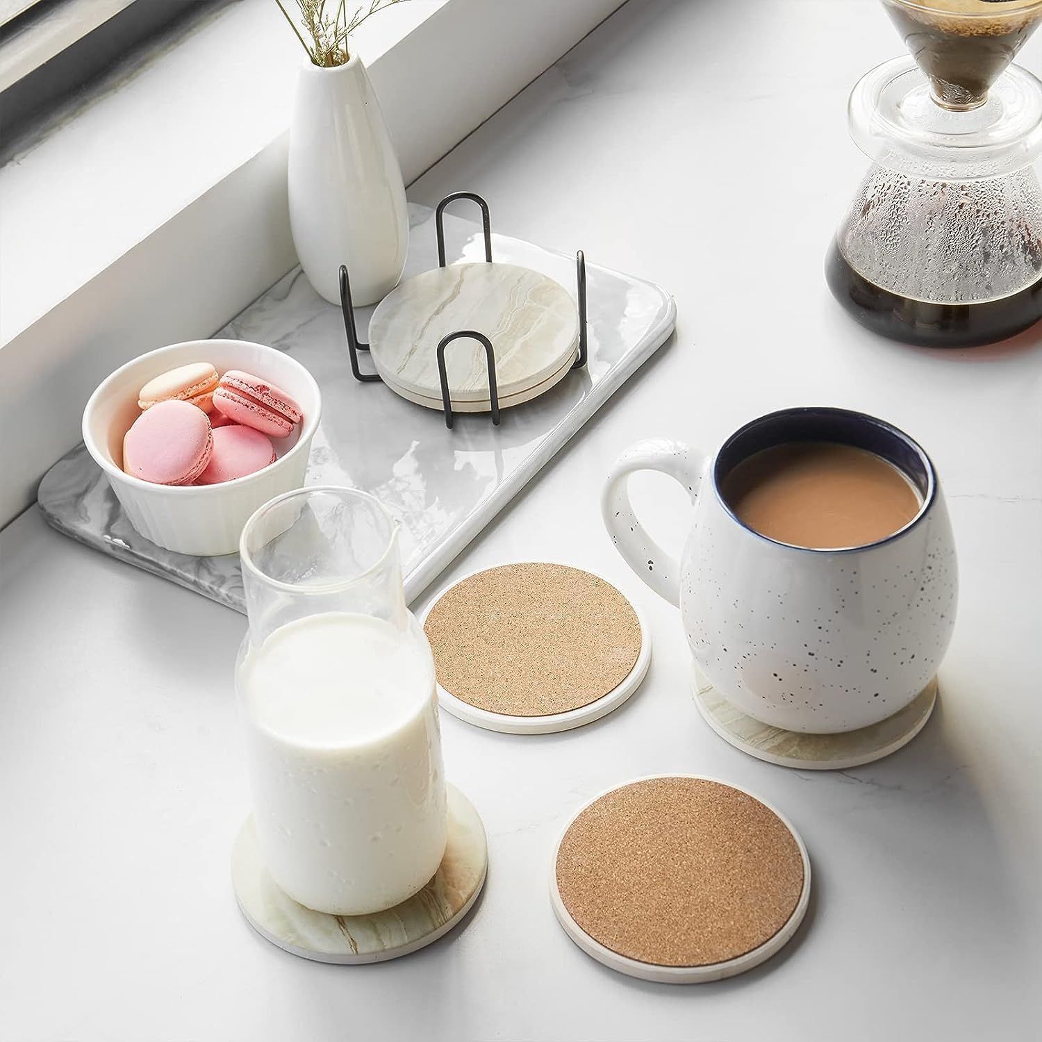 Displays the coasters in an attractive lifestyle context with coffee and snacks to help shoppers envision the product in their daily routine.
