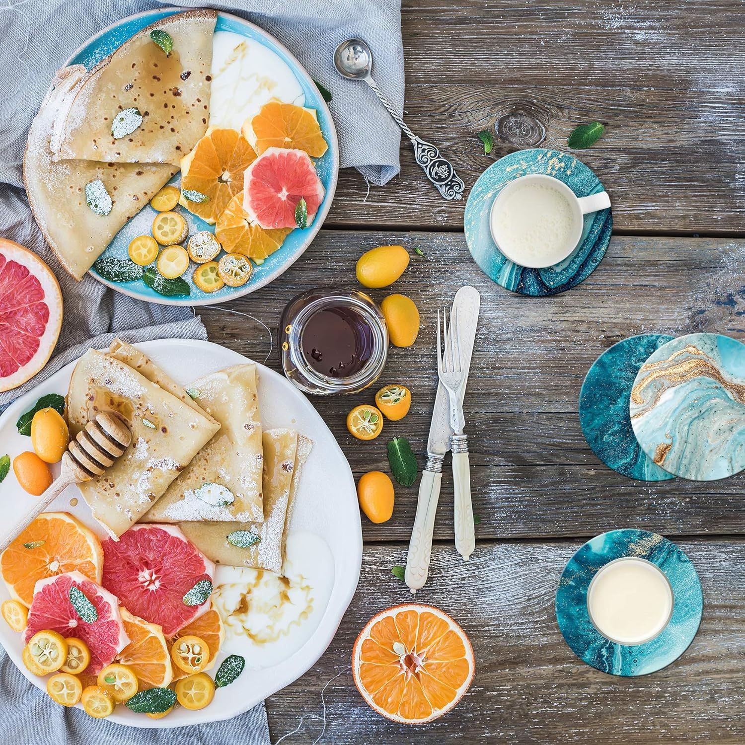Shows the coasters in an aspirational lifestyle setting with food and beverages to help shoppers visualize the product in their own home.