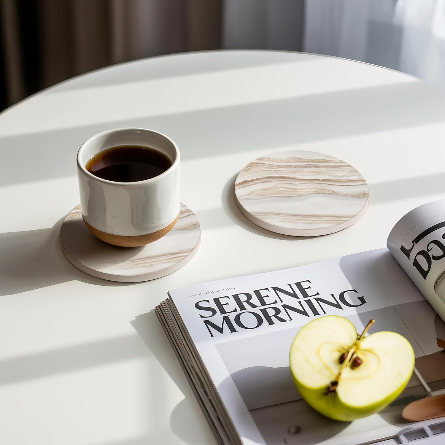 Displays the coasters in a real-world morning setting with coffee and reading materials, helping shoppers visualize the product in their daily routine.