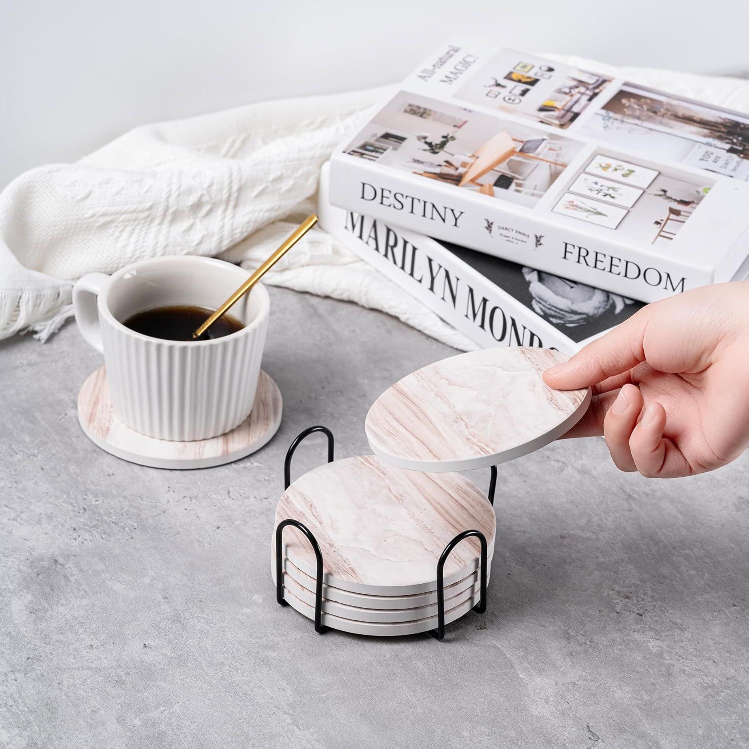Shows the coasters in a real-world home setting with coffee and books to help shoppers visualize the product in their own space.
