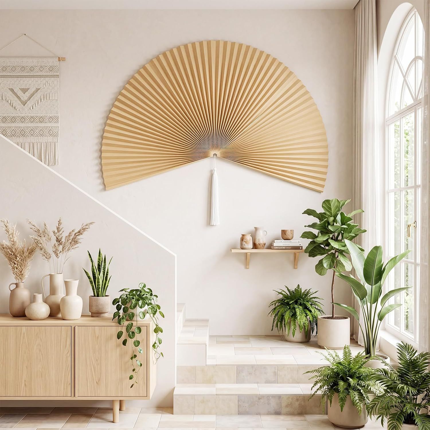 Displays the wall fan in a styled living room environment with plants and natural light to help shoppers envision the product in their own home decor.