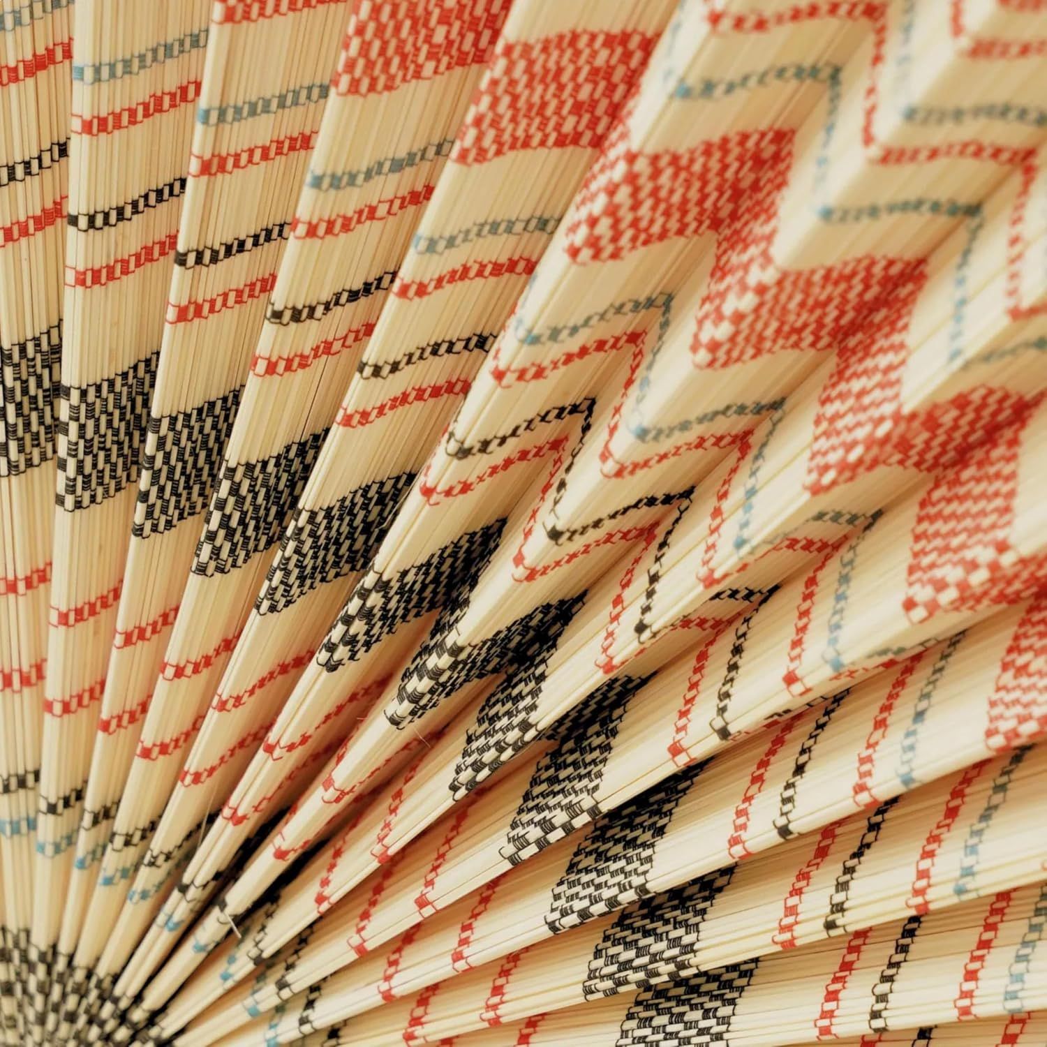 Provides a close-up view of the fan's physical construction, showing the bamboo ribs and woven textile pattern to demonstrate craftsmanship and material quality.